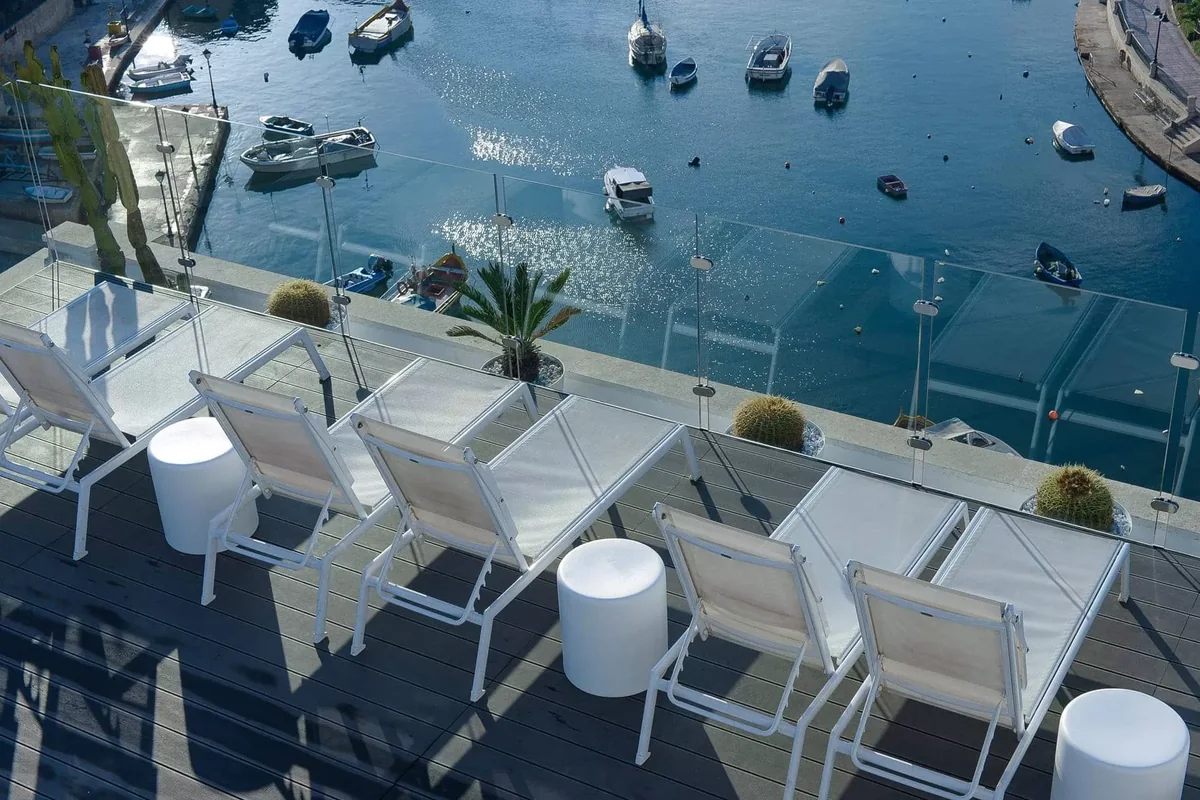 Sun loungers on Hotel Juliani’s terrace overlooking Spinola Bay